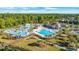 Aerial view of the community pool and waterpark area featuring a lake, a clubhouse, and lush landscaping at 128 Fulbourn Pl., Myrtle Beach, SC 29579