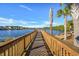 A wooden dock overlooks tranquil lake with palm trees enhancing the waterfront community's serene appeal at 128 Fulbourn Pl., Myrtle Beach, SC 29579