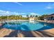 A spacious community pool with a clear blue sky, palm trees, and plenty of lounge chairs for relaxation at 128 Fulbourn Pl., Myrtle Beach, SC 29579
