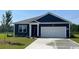 Charming single-story home showcasing blue siding, a two-car garage, and a well-manicured lawn at 214 Carver Willow Dr., Loris, SC 29569