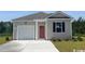 Charming single-story home featuring a one-car garage, red door, and manicured lawn at 218 Carver Willow Dr., Loris, SC 29569