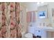 Well-lit bathroom with a pedestal sink, shower with a patterned curtain, and neutral tones at 300 63Rd Ave. N # 306-C, North Myrtle Beach, SC 29582