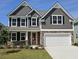 Charming two-story home featuring stone accents, gray siding, a two-car garage, and a well-manicured lawn at 562 Haven View Way, Murrells Inlet, SC 29576