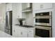 Modern kitchen showcases stainless steel appliances, sleek white cabinetry, and a stylish backsplash at 8476 Duke Pl. # 32, Myrtle Beach, SC 29572