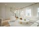 Bright living room with white sofa, plush chair, large windows and hardwood floors at 8476 Duke Pl. # 32, Myrtle Beach, SC 29572
