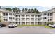 Spacious condo building with multiple balconies, white trim, and ample parking spaces at 109 S Shore Blvd. # 104, Longs, SC 29568