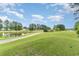 Scenic golf course view with a pond, lush green grass, and golf carts under a bright blue sky at 109 S Shore Blvd. # 104, Longs, SC 29568