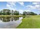 Scenic view of pond reflecting blue sky, trees and green grass in a picturesque golf course community at 109 S Shore Blvd. # 104, Longs, SC 29568