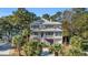 Two-story home with gray metal roof, brick accents, and a landscaped yard at 112 Cockle Shell Ct., Pawleys Island, SC 29585