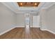 Empty bedroom with wood tray ceiling, hardwood floors, and connecting hallway at 1151 Bear Lake Dr., Longs, SC 29568