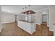 Kitchen area showcases a white kitchen island with granite countertops and stunning chandelier lighting at 1151 Bear Lake Dr., Longs, SC 29568