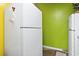 Image of a kitchen with white fridge, yellow and green walls, and simple design at 815 Rogers Dr., Myrtle Beach, SC 29577