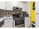 Compact kitchen featuring white cabinets, stainless steel appliances, and tiled backsplash at 815 Rogers Dr., Myrtle Beach, SC 29577