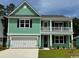 Charming two-story home features a welcoming front porch, light green siding, and attached two car garage at 535 Slaty Dr., Myrtle Beach, SC 29588