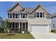 Inviting two-story home featuring a two-car garage, manicured lawn, and charming stone accents around the entryway at 550 Haven View Way, Murrells Inlet, SC 29576