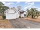 White house with double garage and driveway, surrounded by trees at 1228 Lanterns Rest Rd., Myrtle Beach, SC 29579