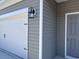 Close-up of the home's exterior, highlighting the siding, garage door, and front door at 301 Palmetto Sand Loop, Conway, SC 29527