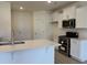 Bright kitchen features white cabinets, stainless steel appliances, and a quartz countertop island at 301 Palmetto Sand Loop, Conway, SC 29527