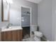 Bathroom featuring tiled floor, wood vanity, modern mirror, and toilet, adjacent to the bedroom at 4502 Boxwood St., Myrtle Beach, SC 29577