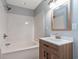 Bathroom includes a tub with shower, wood-look vanity, modern mirror, and white countertop at 4502 Boxwood St., Myrtle Beach, SC 29577