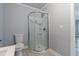 This bathroom has a modern glass shower and a white toilet with neutral tile flooring and gray painted walls at 4502 Boxwood St., Myrtle Beach, SC 29577