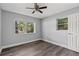 This bedroom features gray walls, wood-look floors, two windows, and a ceiling fan with lights at 4502 Boxwood St., Myrtle Beach, SC 29577