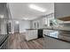 Open kitchen with granite counters, island, and hardwood floors connecting to living area at 4502 Boxwood St., Myrtle Beach, SC 29577