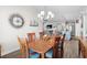 Cozy dining room features a wooden table set, modern chandelier, and views of the open living space at 6550 Anterselva Dr., Myrtle Beach, SC 29572