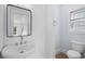 This half bath features a pedestal sink, wood paneled walls, and a window for natural light at 2302 Seaseeker Ln., Myrtle Beach, SC 29577