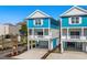 Beautiful view of two-story coastal homes with blue exteriors, white trim, and well-manicured landscaping at 2302 Seaseeker Ln., Myrtle Beach, SC 29577