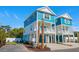 Inviting two-story coastal home showcasing its blue exterior, white trim, and lush tropical landscaping at 2302 Seaseeker Ln., Myrtle Beach, SC 29577