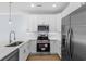 Modern kitchen featuring stainless steel appliances, white cabinets, and a contrasting light blue wall at 2302 Seaseeker Ln., Myrtle Beach, SC 29577