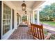 Inviting front porch with brick flooring, rocking chairs, and elegant lantern lighting at 356 Rossdhu Ave., Pawleys Island, SC 29585