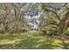 A charming white home is showcased through mossy trees and a lush, green lawn at 356 Rossdhu Ave., Pawleys Island, SC 29585