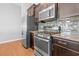 Close up showcasing stainless steel appliances, dark cabinetry, and a stylish backsplash in the kitchen at 4463 Livorn Loop # 4463, Myrtle Beach, SC 29579