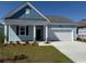 Charming one-story home showcasing light blue siding, a neatly manicured lawn, and a two-car garage at 544 Duvall St., Longs, SC 29568