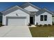Charming one-story home with white siding, manicured lawn, and a two-car garage at 552 Duvall St., Longs, SC 29568