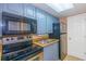 Small kitchen with blue cabinets and black appliances at 6804 N Ocean Blvd. # 1009, Myrtle Beach, SC 29572