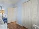 Bedroom with wood floors, soft blue walls, double closet, and a decorative nautical-themed bedside table with lamp at 702 Plantation Dr., Surfside Beach, SC 29575