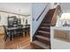 View of the dining room, leading to a staircase, with a 'Welcome to Paradise' sign at 702 Plantation Dr., Surfside Beach, SC 29575