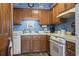 Classic kitchen featuring oak cabinets, a double sink, and essential appliances in a well-maintained condition at 702 Plantation Dr., Surfside Beach, SC 29575