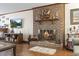 A cozy living room featuring a brick fireplace, hardwood floors, and a television for relaxing or entertaining at 702 Plantation Dr., Surfside Beach, SC 29575