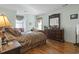 Cozy main bedroom with hardwood floors, large dresser, and plenty of natural light at 702 Plantation Dr., Surfside Beach, SC 29575