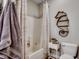 Cozy bathroom features a shower with decorative curtain, a seahorse wall decoration and white fixtures at 8605 Hopper Ct., Myrtle Beach, SC 29579