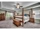 Bright main bedroom featuring a four-poster bed, a seating area, and a tray ceiling at 8605 Hopper Ct., Myrtle Beach, SC 29579