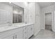 Bright bathroom with double sinks, white cabinets, gray tile flooring, and a large mirror at 2048 Copper Creek Loop, Longs, SC 29568