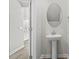 Stylish bathroom with a pedestal sink and decorative oval mirror, reflecting a bright and clean space at 2048 Copper Creek Loop, Longs, SC 29568