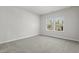 A bright bedroom with neutral carpet, two windows with blinds allowing plenty of natural light at 2048 Copper Creek Loop, Longs, SC 29568
