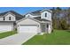Inviting home with a spacious driveway leading to an attached two-car garage and a lush green lawn at 2048 Copper Creek Loop, Longs, SC 29568
