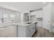 Well-lit kitchen showcasing an island with sink, stainless steel appliances, and bright white cabinets at 2048 Copper Creek Loop, Longs, SC 29568